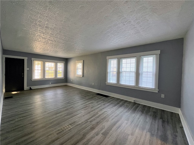 unfurnished room with a textured ceiling and dark wood-type flooring