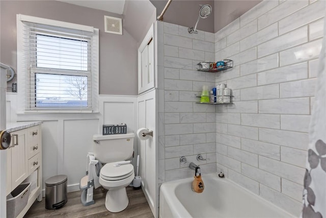 bathroom featuring shower / bathtub combination with curtain, hardwood / wood-style floors, and toilet