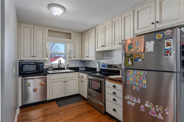 kitchen with stainless steel appliances, dark hardwood / wood-style floors, sink, and decorative backsplash