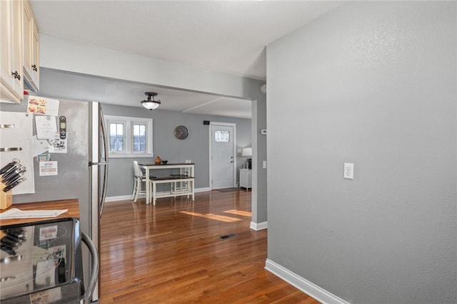 kitchen with range with electric cooktop, dark wood-type flooring, and stainless steel fridge