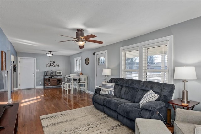 living room with ceiling fan and dark hardwood / wood-style floors