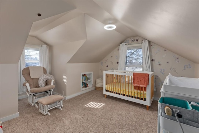 carpeted bedroom featuring a crib and vaulted ceiling