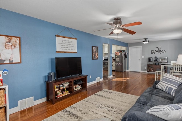 living room featuring dark wood-type flooring and ceiling fan