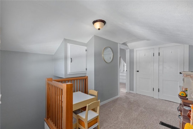 additional living space featuring lofted ceiling and light colored carpet