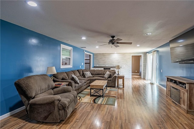 living room featuring ceiling fan and light hardwood / wood-style flooring