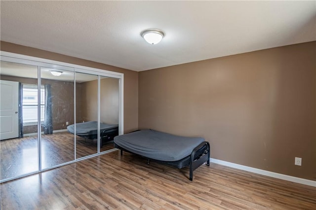 bedroom with light hardwood / wood-style floors and a closet