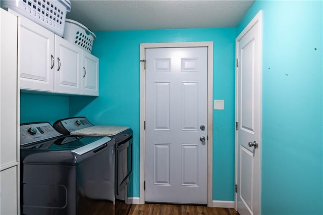 laundry area featuring cabinets, washing machine and dryer, dark hardwood / wood-style floors, and a textured ceiling