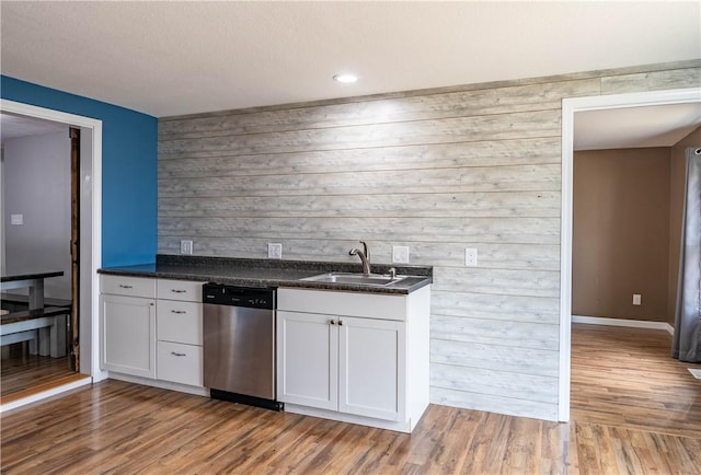 kitchen featuring sink, white cabinets, dishwasher, and light wood-type flooring