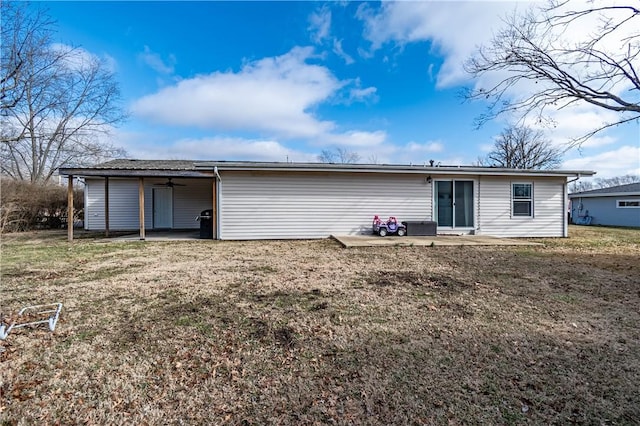 back of property with a lawn and a patio