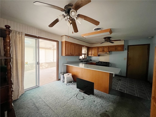 kitchen featuring ceiling fan, sink, dark colored carpet, kitchen peninsula, and black range