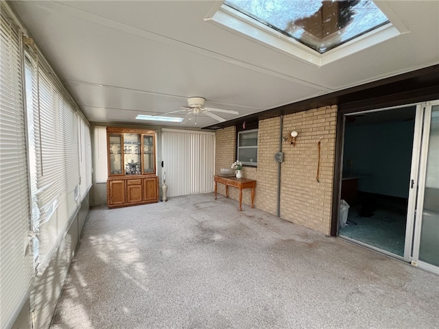 unfurnished sunroom featuring a skylight and ceiling fan