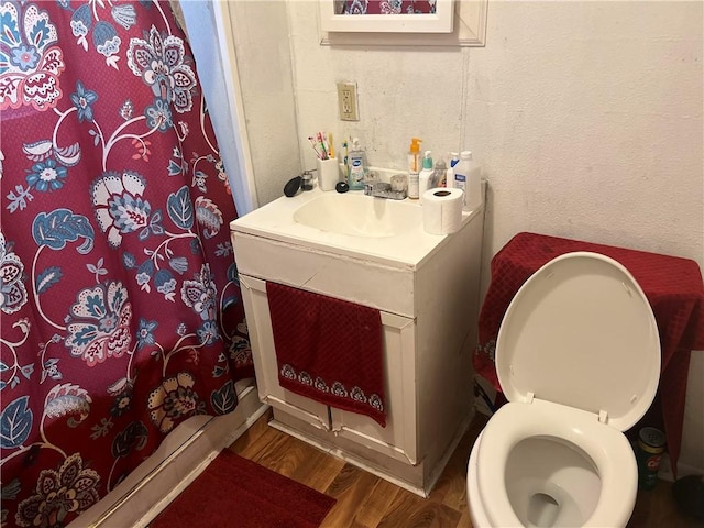 bathroom featuring vanity, a shower with shower curtain, wood finished floors, and toilet