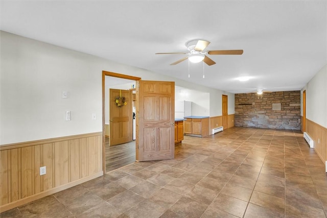 unfurnished room featuring ceiling fan and a baseboard heating unit