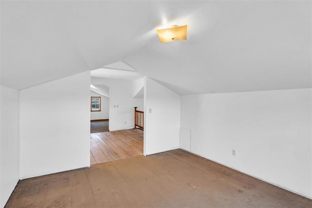 additional living space featuring lofted ceiling and hardwood / wood-style floors