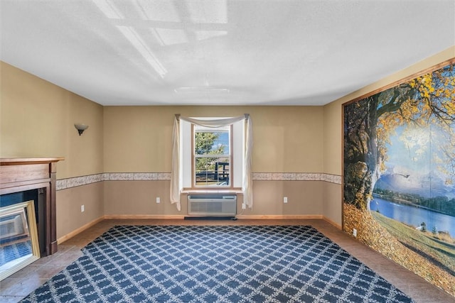 unfurnished living room featuring an AC wall unit and a textured ceiling