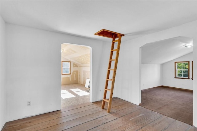 bonus room with lofted ceiling, light wood-type flooring, and a wealth of natural light