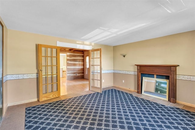 unfurnished living room featuring french doors and carpet floors