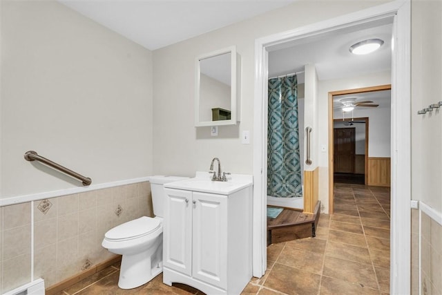 bathroom with toilet, vanity, and ceiling fan