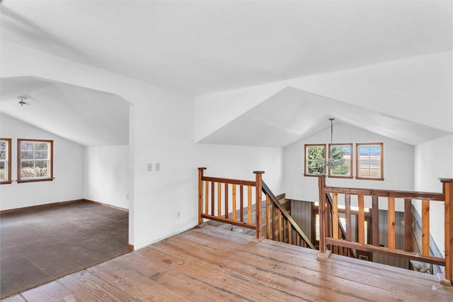 bonus room with vaulted ceiling and light hardwood / wood-style flooring