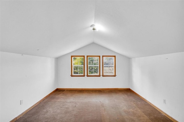 bonus room with vaulted ceiling and carpet flooring