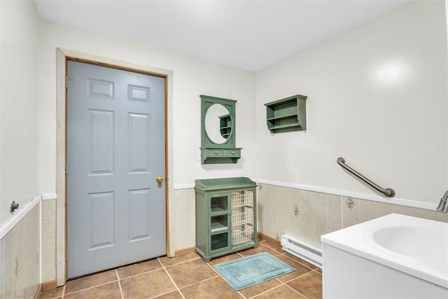 bathroom featuring tile walls, tile patterned floors, vanity, and a baseboard heating unit