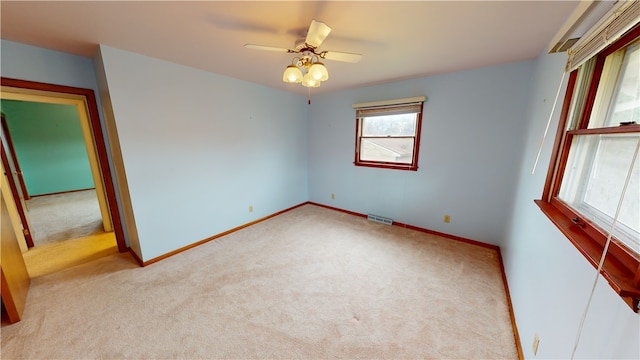 carpeted spare room with ceiling fan