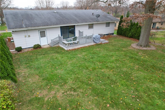 rear view of property featuring a lawn and a wooden deck