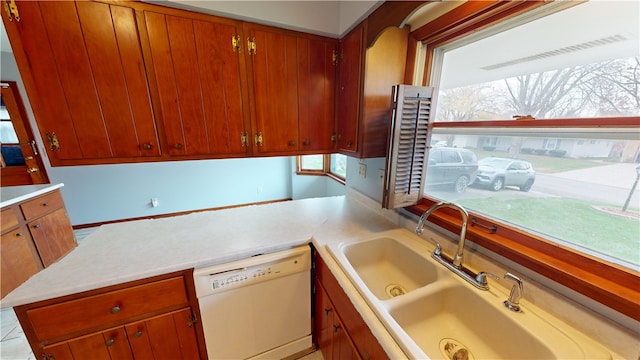 kitchen featuring plenty of natural light, white dishwasher, and sink