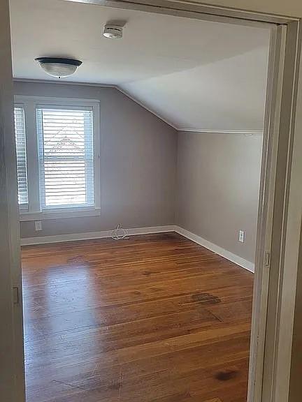 203 N E St, Olney, IL 62450 - bonus room with baseboards, lofted ceiling, and wood finished floors