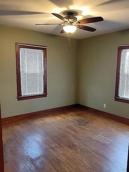 203 N E St, Olney, IL 62450 - empty room featuring dark wood-style floors, baseboards, and ceiling fan