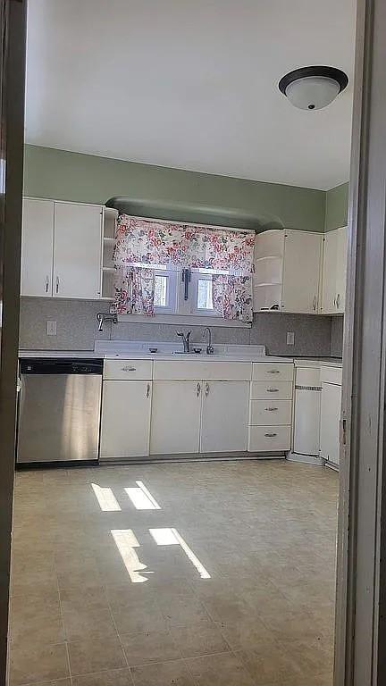 203 N E St, Olney, IL 62450 - kitchen with stainless steel dishwasher, open shelves, white cabinetry, a sink, and decorative backsplash