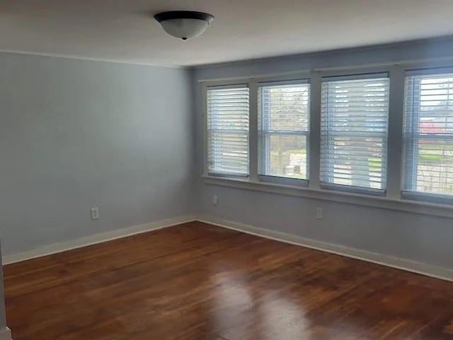 203 N E St, Olney, IL 62450 - spare room with dark wood-style flooring and baseboards
