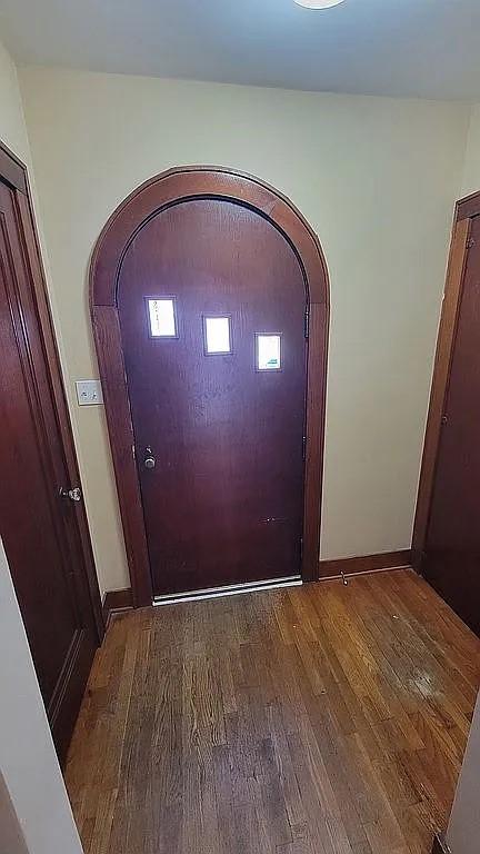 203 N E St, Olney, IL 62450 - entryway featuring arched walkways, wood finished floors, and baseboards