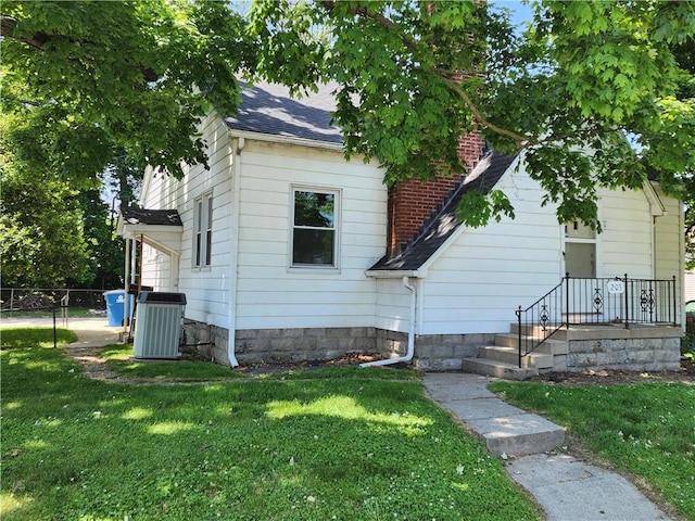 203 N E St, Olney, IL 62450 - bungalow-style home with central AC, roof with shingles, and a chimney