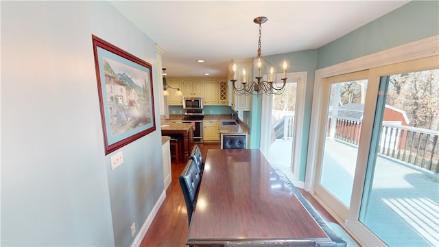 dining space with a chandelier, wood finished floors, and baseboards