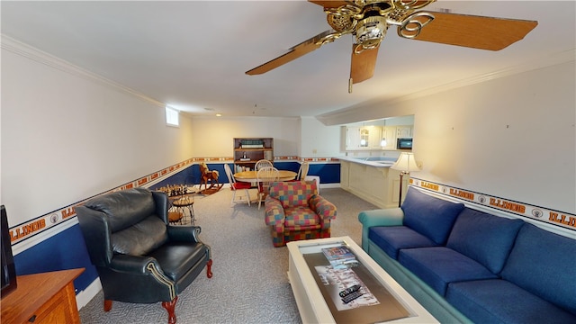 carpeted living area featuring ornamental molding and a ceiling fan