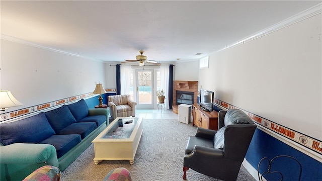 carpeted living room featuring visible vents, a glass covered fireplace, a ceiling fan, and crown molding