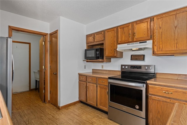 11444 N 800th St, Effingham, IL 62401 - kitchen with appliances with stainless steel finishes, under cabinet range hood, light wood-type flooring, brown cabinets, and light countertops