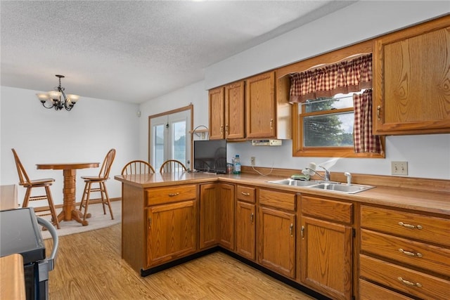 11444 N 800th St, Effingham, IL 62401 - kitchen featuring stove, brown cabinets, a peninsula, light wood-style flooring, and healthy amount of natural light