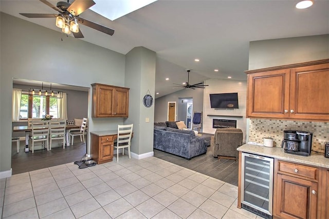 7950 Lehman Rd, Decatur, IL 62521 - kitchen featuring wine cooler, ceiling fan, vaulted ceiling, brown cabinets, and light tile patterned floors