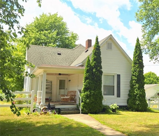 406 S Gray St, Sidell, IL 61876 - back of house with covered porch, a chimney, a lawn, and a shingled roof
