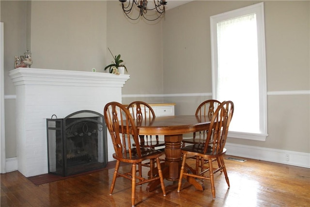 302 W N 3rd St, Shelbyville, IL 62565 - dining space featuring a chandelier, wood finished floors, a fireplace with flush hearth, and baseboards