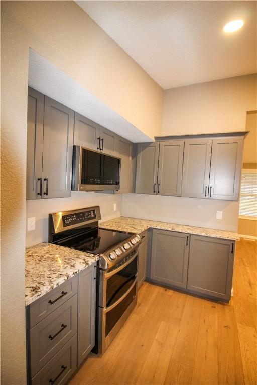 kitchen featuring decorative light fixtures, kitchen peninsula, dishwasher, and a kitchen bar