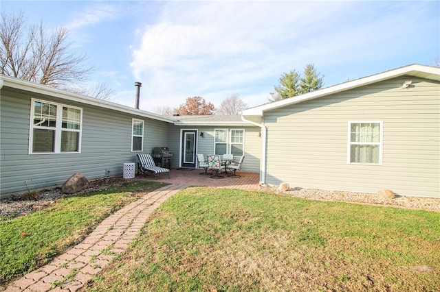 back of property with a lawn and a patio area