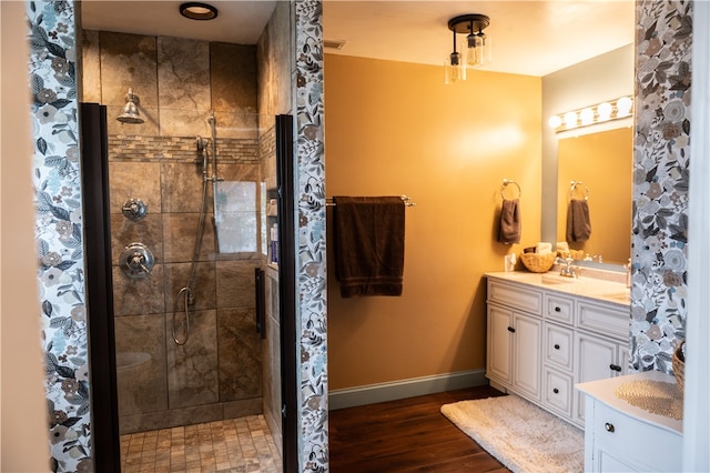 bathroom featuring hardwood / wood-style flooring, vanity, and a shower with shower door