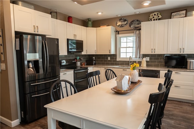 kitchen with dark wood-type flooring, sink, appliances with stainless steel finishes, tasteful backsplash, and white cabinetry