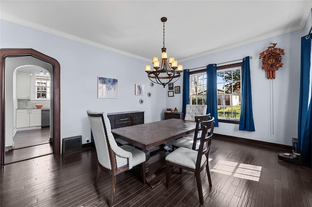 dining room with arched walkways, dark wood-style flooring, baseboards, a notable chandelier, and crown molding
