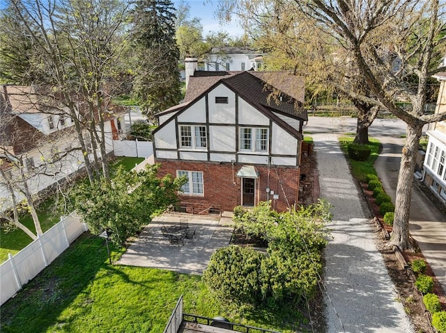 rear view of house featuring a fenced backyard, stucco siding, a yard, brick siding, and a patio area