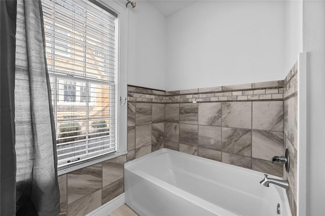bathroom featuring a bath and tile walls