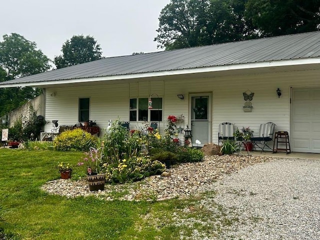 9275 N 890th St, Effingham, IL 62401 - view of front facade featuring a front lawn, an attached garage, a metal roof, and covered porch